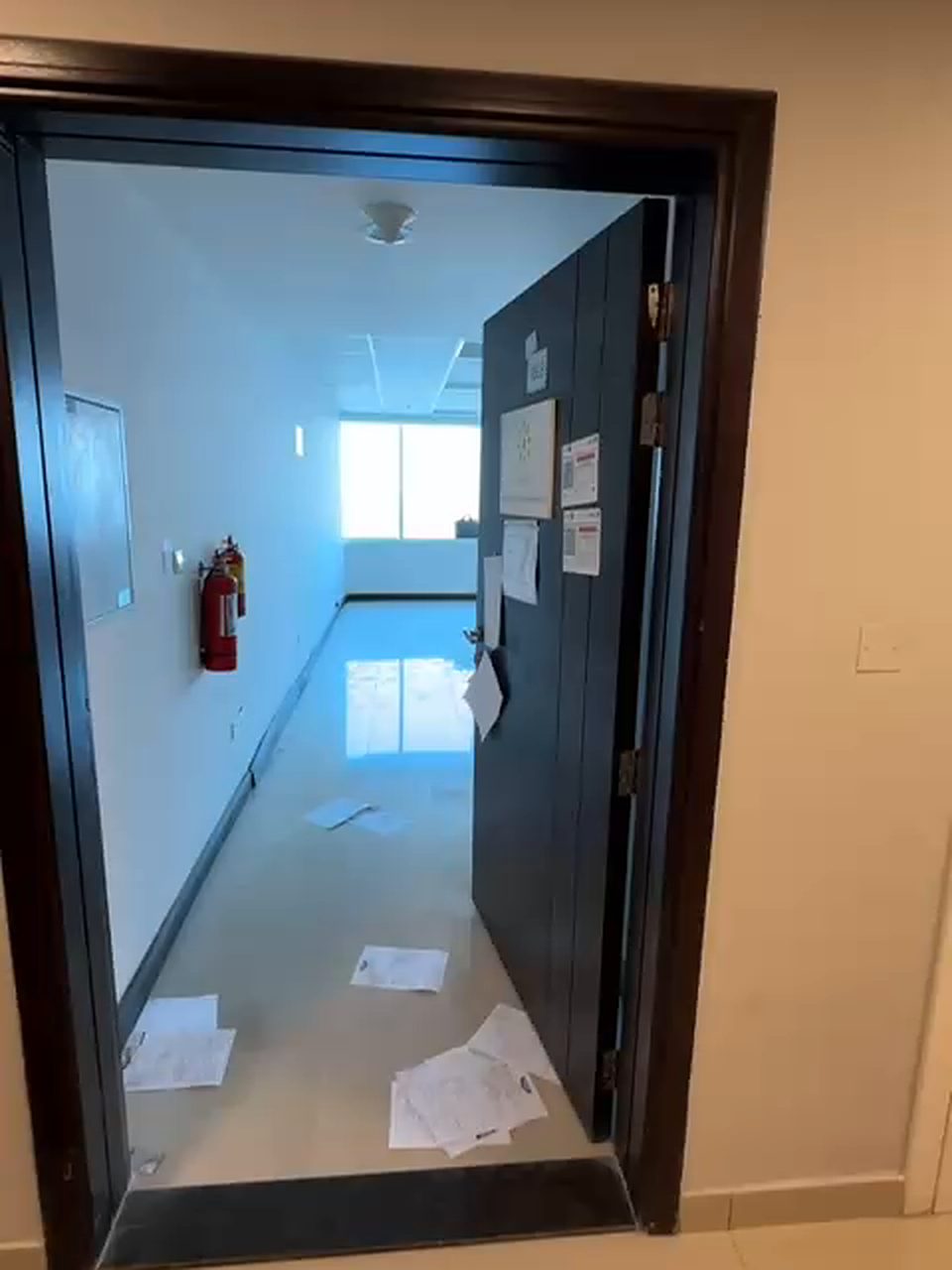 Before: bare entrance with a dark timber door and an empty, unfinished corridor